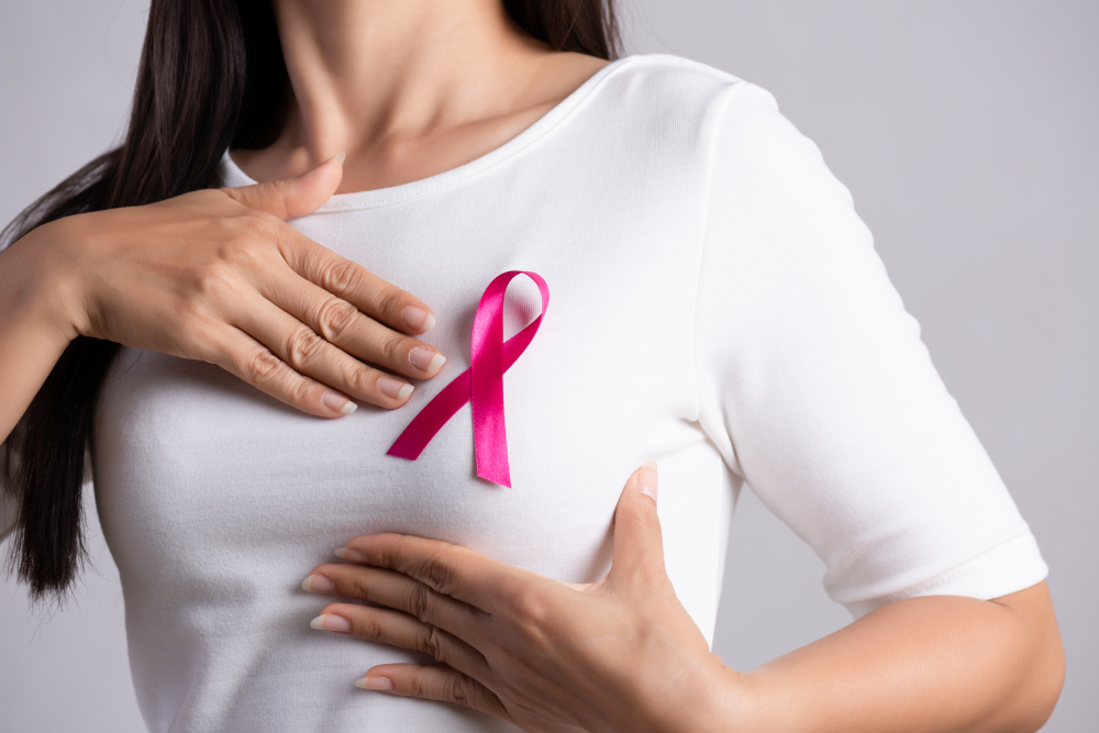 Mujer portando la insignia del cáncer de mama en su camisa blanca